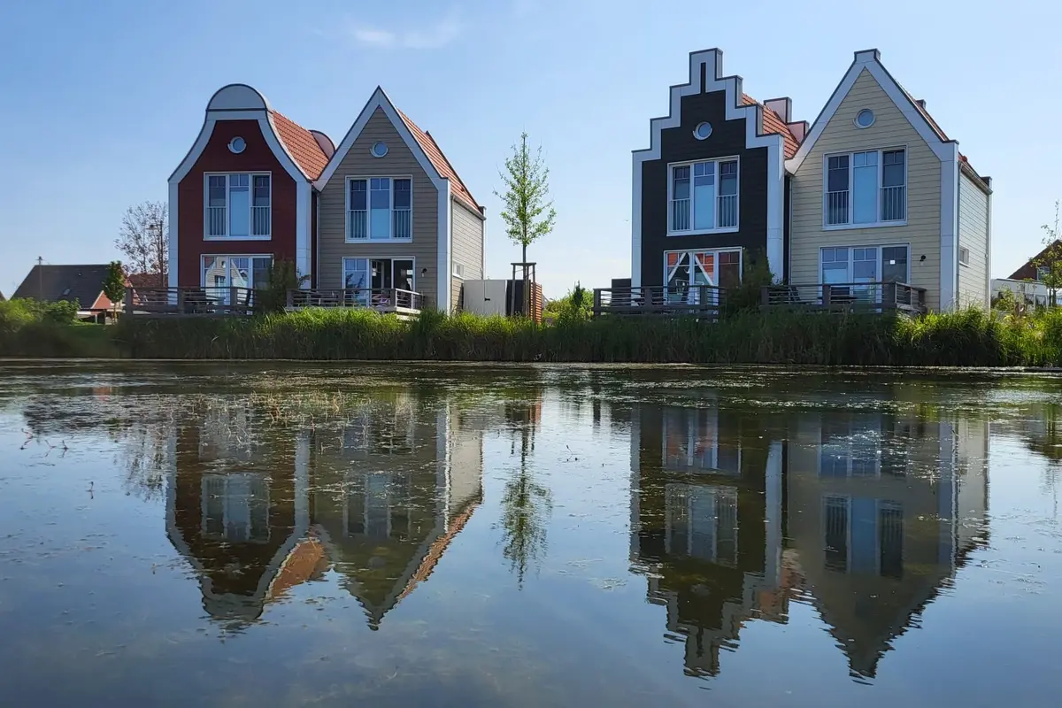 Vier Ferienhäuser am Ufer spiegeln sich im Wasser
