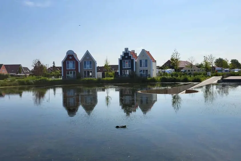 Ferienhäuser spiegeln sich im Wasser am Abend